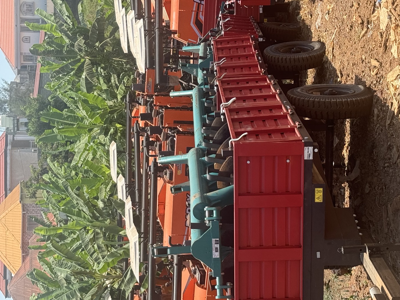 Remorques et charrues alignées dans le parc de machines agricoles d'ABIG.